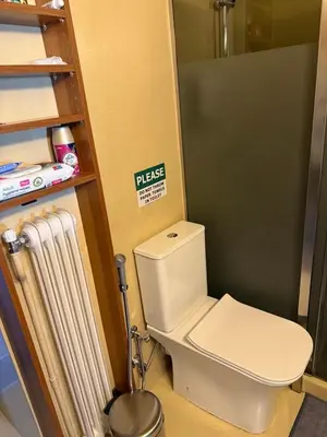 a bathroom with a toilet with a sign on the wall at Charming apartment in Glyfada in Athens