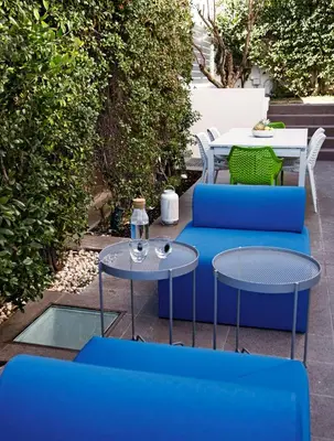 a patio with two blue chairs and a table at Stefano's Villa Lagonissi in Lagonissi