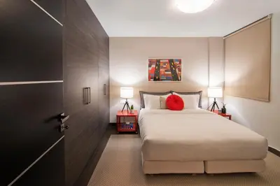 a bedroom with a bed with a red pillow at Stefano's Villa Lagonissi in Lagonissi
