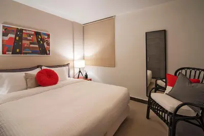 a bedroom with a large white bed and a chair at Stefano's Villa Lagonissi in Lagonissi