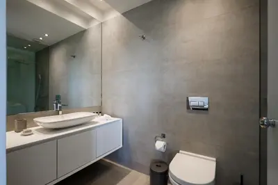 a bathroom with a sink and a toilet and a mirror at Ellinikon Luxury Apartment in Athens