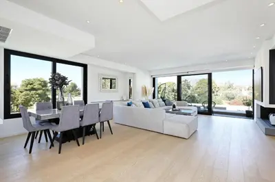 a white living room with a table and a couch at Ellinikon Luxury Apartment in Athens