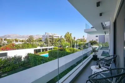 a balcony with chairs and a view of a garden at Ellinikon Luxury Apartment in Athens