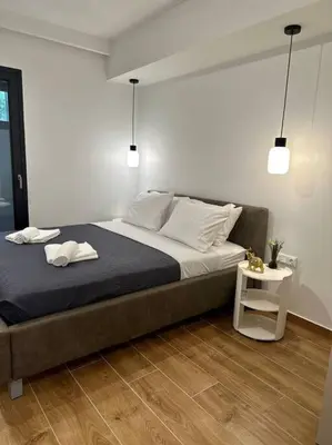 a bedroom with a large bed and a side table at Moschato Stylish Home 1 VIPGreece in Piraeus
