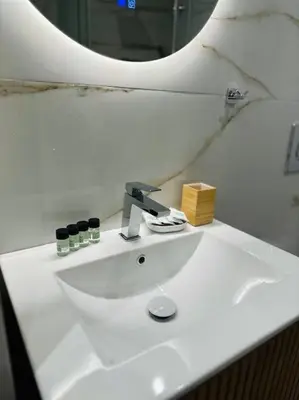 a white sink in a bathroom with a mirror at Moschato Stylish Home 1 VIPGreece in Piraeus