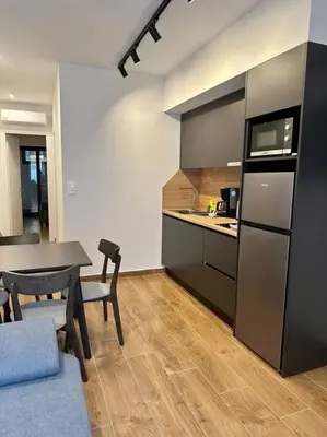 a kitchen and dining room with a table and a refrigerator at Moschato Stylish Home 1 VIPGreece in Piraeus