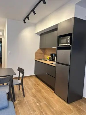 a kitchen with a black refrigerator and a table at Moschato Stylish Home 1 VIPGreece in Piraeus
