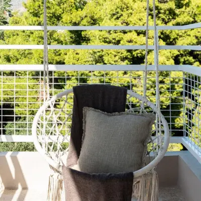 a white chair with a pillow on a porch at 2-BD Luxury Apt Sea View Balcony near the beach in Athens