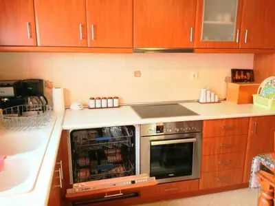 a kitchen with wooden cabinets and a stove top oven at Angela's Home (Near Athens Airport) in Spáta