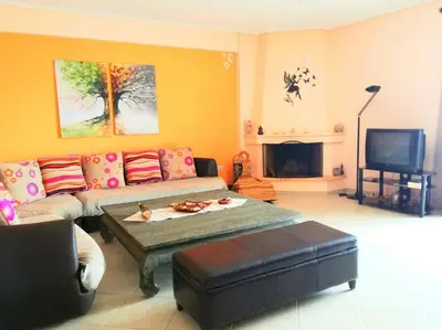 a living room with a couch and a tv at Angela's Home (Near Athens Airport) in Spáta