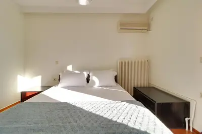 a bedroom with a large bed with white sheets at Chalandri Family Penthouse - 1' from metro station in Athens