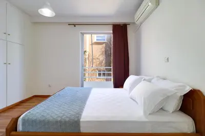 a bedroom with a white bed with a window at Chalandri Family Penthouse - 1' from metro station in Athens