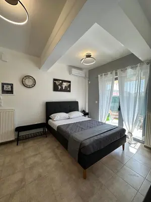 a bedroom with a bed and a clock on the wall at Elegant Escapes 4 in Athens