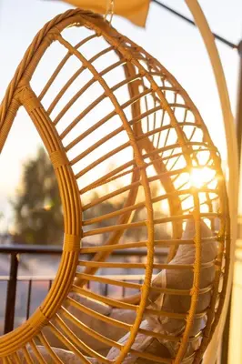 a person sitting in a wicker rattan chair at AIOLOS GLYFADA super lux suite 5 sea view in Athens