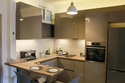 a kitchen with brown cabinets and a counter top at AIOLOS GLYFADA super lux suite 5 sea view in Athens