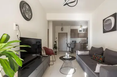 a living room with a couch and a table at AIOLOS GLYFADA super lux suite 5 sea view in Athens