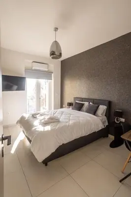 a bedroom with a large bed and a large window at AIOLOS GLYFADA super lux suite 5 sea view in Athens