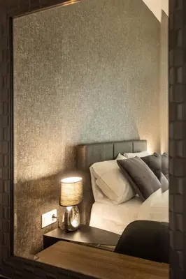 a mirror reflection of a bedroom with a bed at AIOLOS GLYFADA super lux suite 5 sea view in Athens