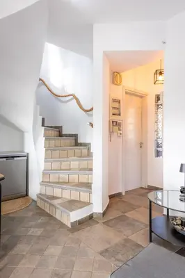 a staircase in a living room with a table at Porto Rafti Hideaway in Porto Rafti