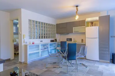 a kitchen with blue cabinets and a table and chairs at Porto Rafti Hideaway in Porto Rafti