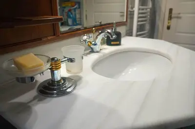 a white bathroom sink with a soap dispenser on it at Katerina's apartment in Athens