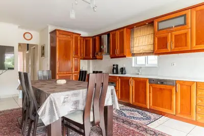 a kitchen with wooden cabinets and a table with chairs at Katerina's apartment in Athens