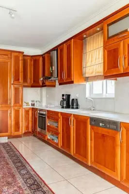 a large kitchen with wooden cabinets and appliances at Katerina's apartment in Athens