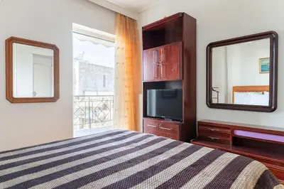 a bedroom with a bed and a tv and a mirror at Katerina's apartment in Athens