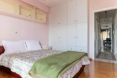 a bedroom with a bed with a green blanket on it at Katerina's apartment in Athens