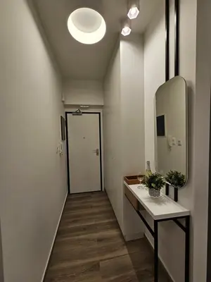 a hallway with a bathroom with a sink and a mirror at Platon Stylish Apartment in Athens