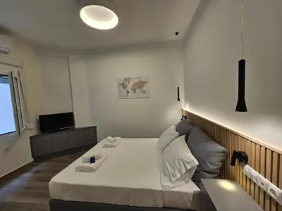 a small room with a bed and a television at Platon Stylish Apartment in Athens