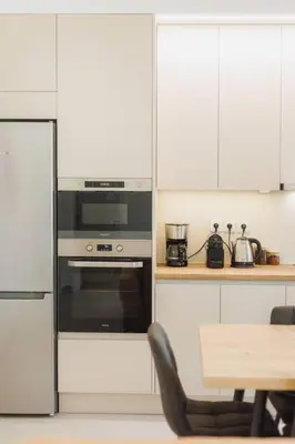 a kitchen with a stove and a table with a chair at Lavish condo in Athens Riviera in Athens