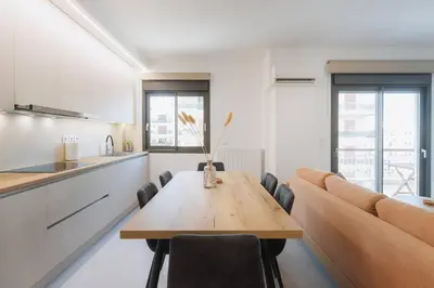 a kitchen and dining room with a table and a couch at Lavish condo in Athens Riviera in Athens