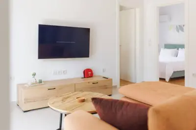 a living room with a couch and a tv at Lavish condo in Athens Riviera in Athens