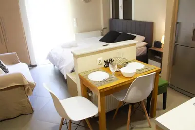 a small room with a table and chairs and a bed at AIOLOS VOULA near the sea apartment in Athens