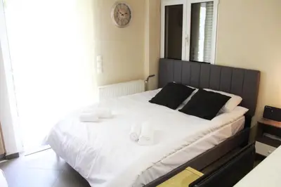 a bedroom with a large bed with two towels on it at AIOLOS VOULA near the sea apartment in Athens