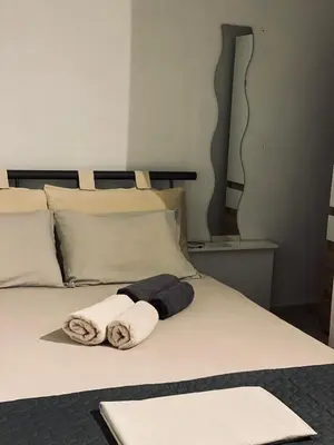 a bed with two towels on it at Cosy House Glyfada in Athens