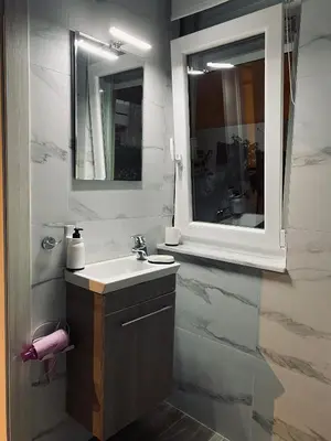 a bathroom with a sink and a mirror at Cosy House Glyfada in Athens
