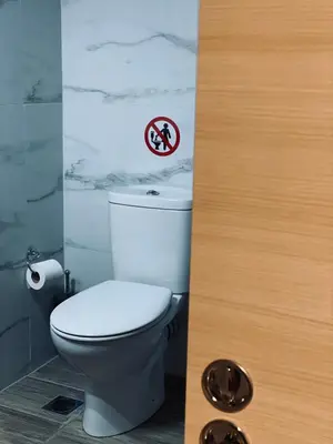 a bathroom with a toilet with a sign on the wall at Cosy House Glyfada in Athens