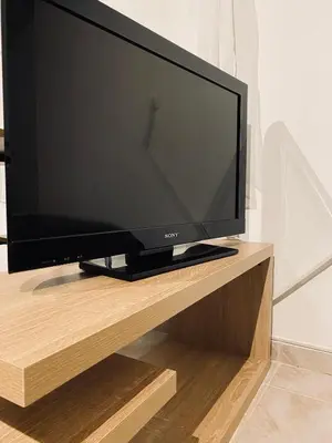 a flat screen tv sitting on a wooden stand at Cosy House Glyfada in Athens