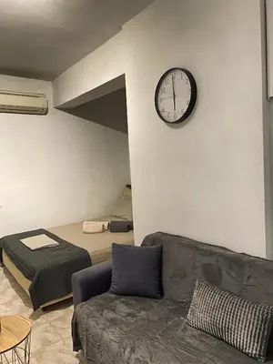 a room with a couch and a clock on the wall at Cosy House Glyfada in Athens