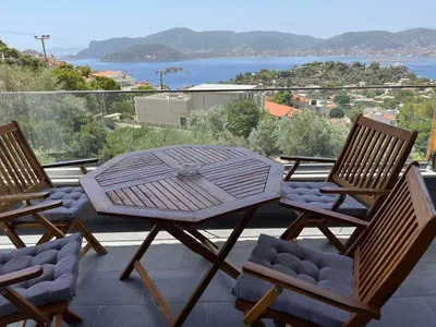 a table and chairs on a patio with a view of the water at Zinia House in Porto Rafti