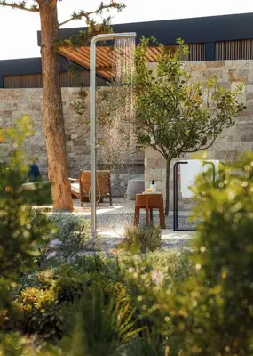 a garden with a bench and a tree and a building at One&Only Aesthesis, Athens in Athens