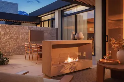 a fireplace in a patio with a table and chairs at One&Only Aesthesis, Athens in Athens