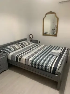 a bedroom with a bed with a mirror on the wall at Παραθαλάσσιο στούντιο με κήπο in Saronida