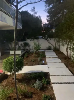 a garden with stone walkways in a yard at Παραθαλάσσιο στούντιο με κήπο in Saronida