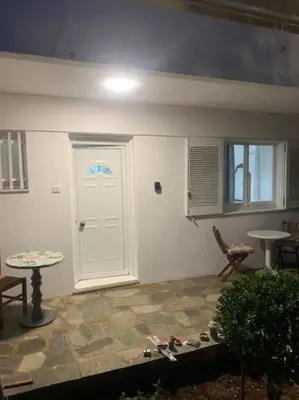 a room with a white door and a table and a window at Παραθαλάσσιο στούντιο με κήπο in Saronida