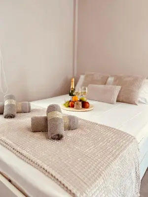 a white bed with a table with fruit on it at Cactus Luxury suite1 in Athens