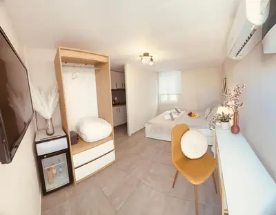 a small room with a bed and a table and chair at Cactus Luxury suite1 in Athens