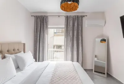 a bedroom with a white bed and a window at Afroditi Suite in Athens